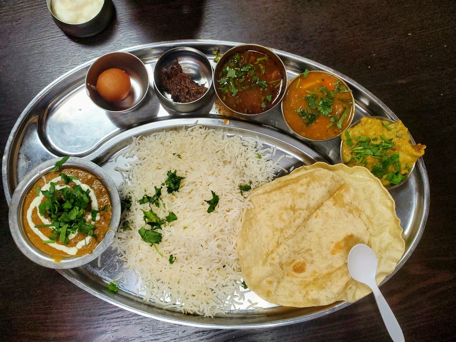 A full steel thali with rice, daal, two curries, papad and roti